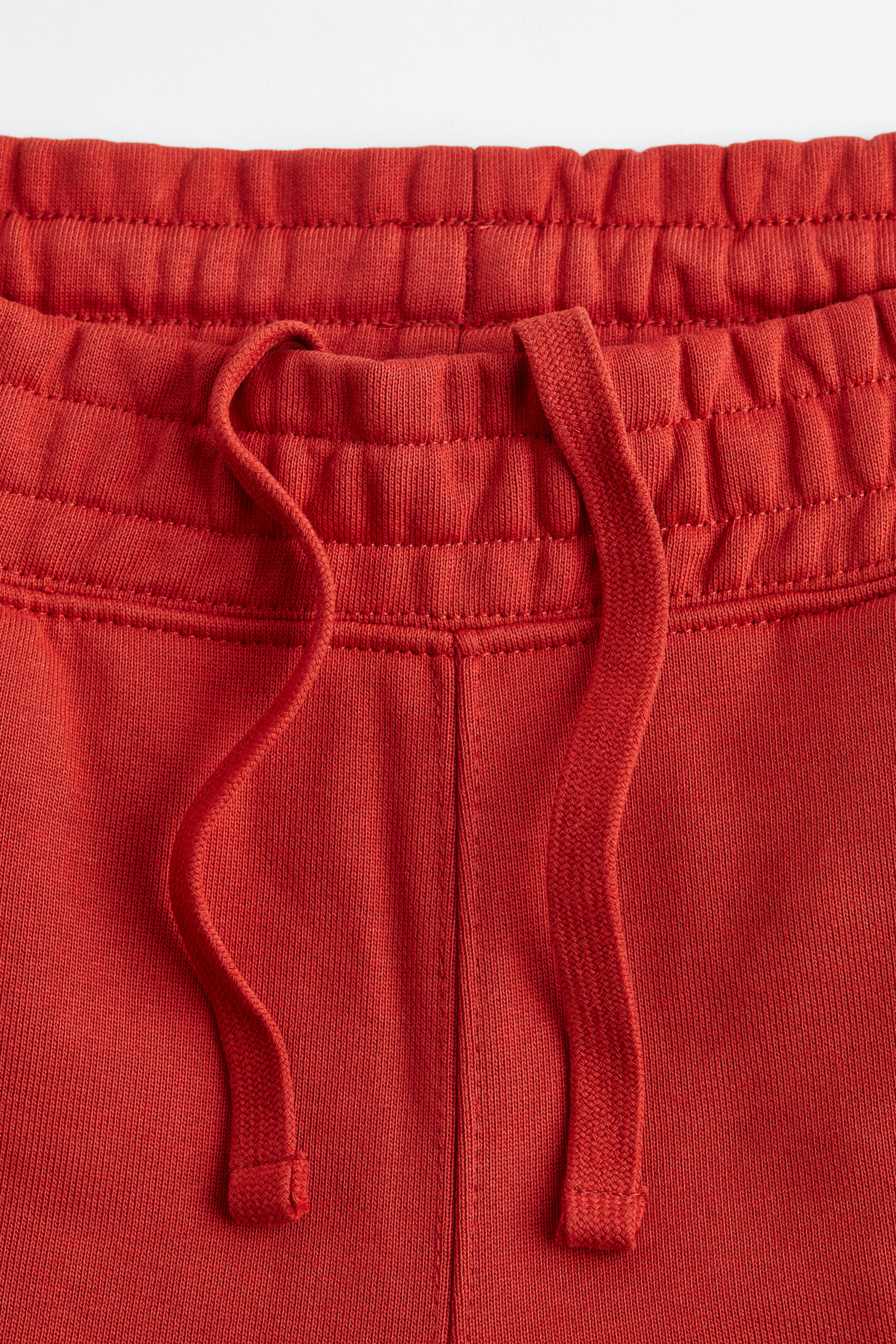 Relaxed Fit Cotton joggers - Regular waist - Long - Crimson red - Men | H&M GB